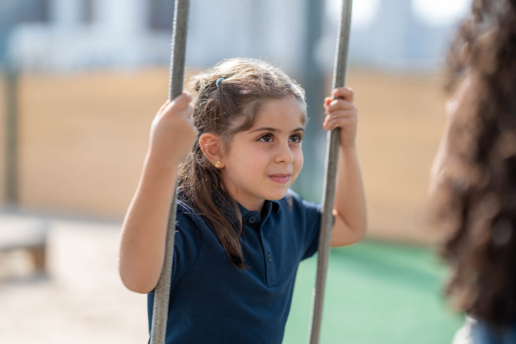 Girl on swing, smiling happily.
